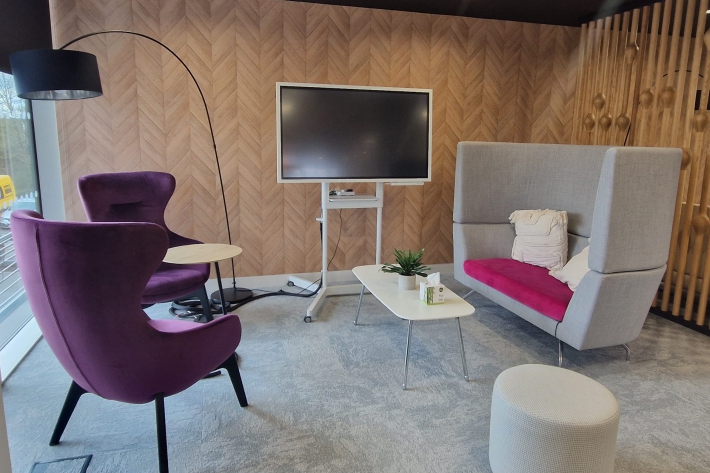 Breakout area with an interactive screen and comfortable seating.