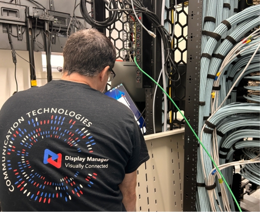 Marcello working on Av Rack Display Manager AV/IT technician working by the rack. Commissioning.