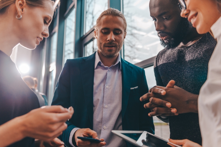Unified Communications - team streaming on thier phones and laptops Unified Communications concept - A team streaming content on their mobile phones and laptops