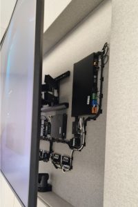 Display screen in a meeting room pulled away from the wall to reveal the integrations behind it.